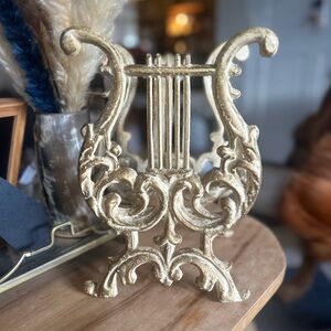 Elegant cast iron Gold creme harp decor.  Magazine rack, books albums 11”H